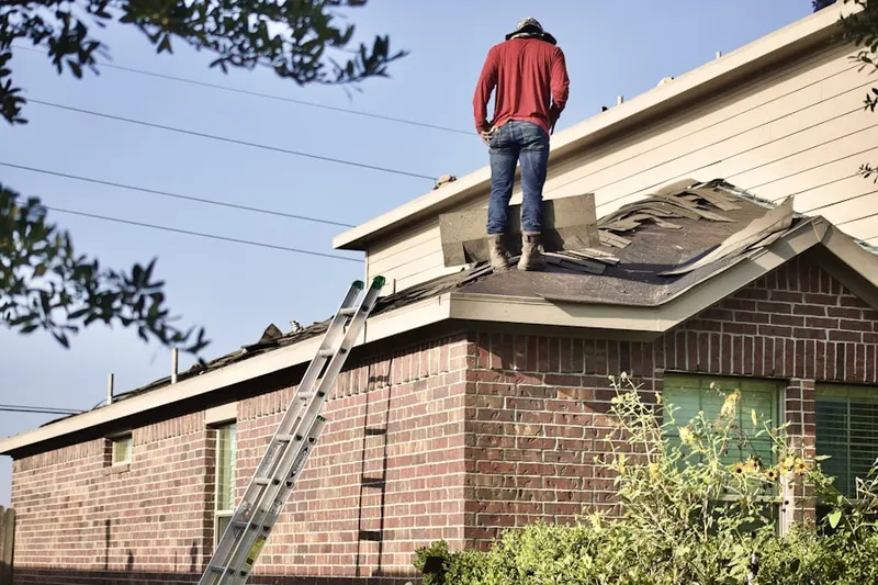 Professional roofer working on a residential roof in Biedman